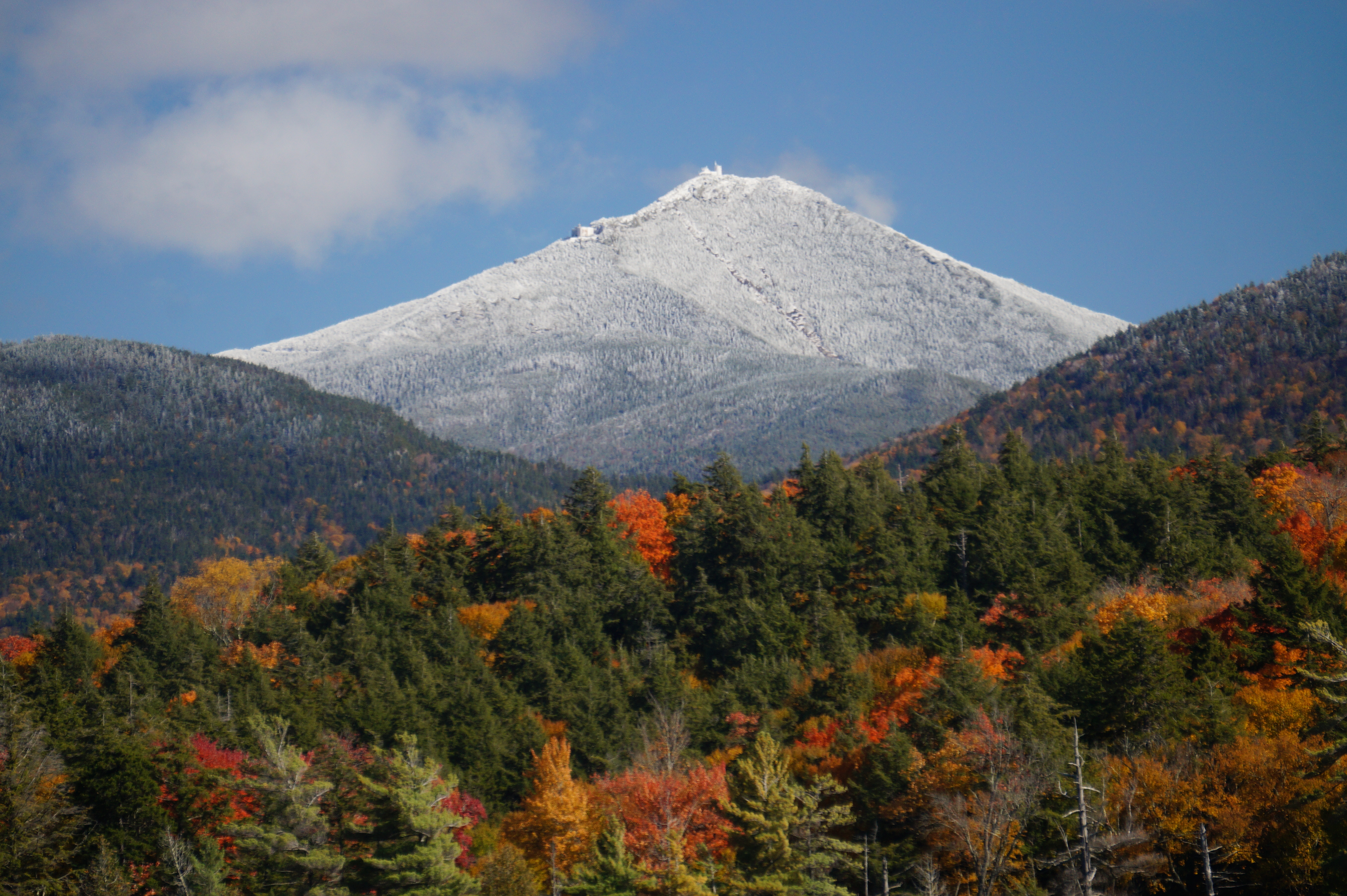 Whiteface Mountain whitecapped with fall trees in the foreground.