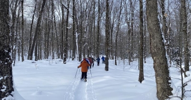 A group snowshoeing down Rainbow Falls Trail